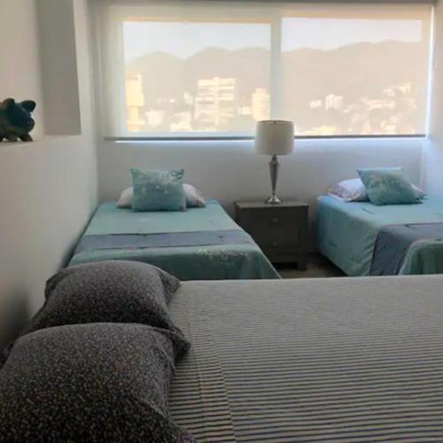 アカプルコにあるApartamento con Piscina Frente al Mar en Acapulcoのベッドルーム1室(ベッド2台、窓付)