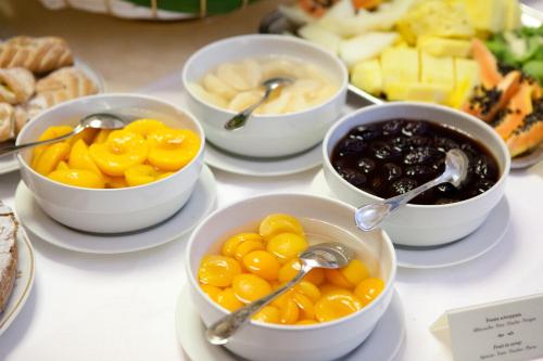 a table topped with bowls of food with spoons at Santa Barbara Hotel in San Donato Milanese