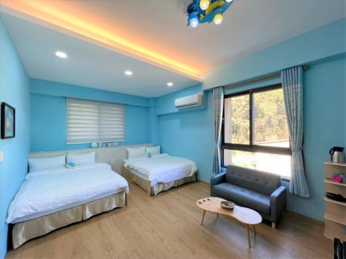 two beds in a room with blue walls at 2H-share home in Yuchi
