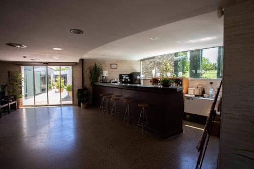 a large kitchen with a bar with stools in it at Arcs De Monells - Adults Only in Monells