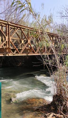 a bridge over a river with water rushing underneath at ירוק בטבע in Sheʼar Yashuv