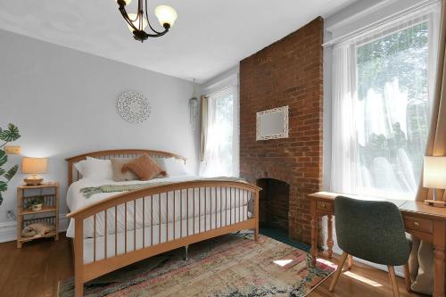 um quarto com uma cama e uma parede de tijolos em Modern Boho Stylish 1BR Near DT on Historic Street em Columbus