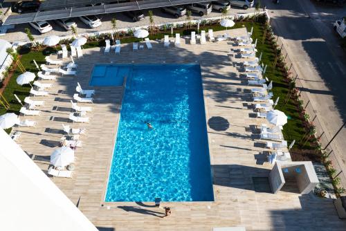 una vista sul tetto di una piscina con ombrelloni e sedie di Life Hotel a Bibione