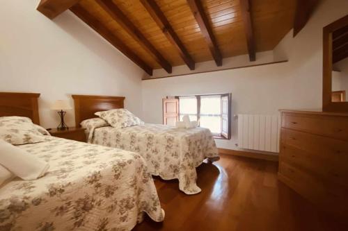 1 dormitorio con 2 camas y ventana en Apartamentos Rurales LLeguera en Llanes
