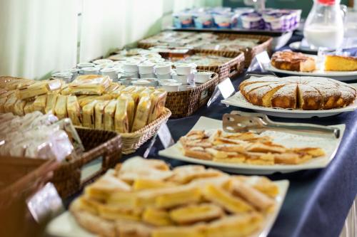 a table with many different types of bread and pastries at Amadei Hotel Blumen in Pesaro