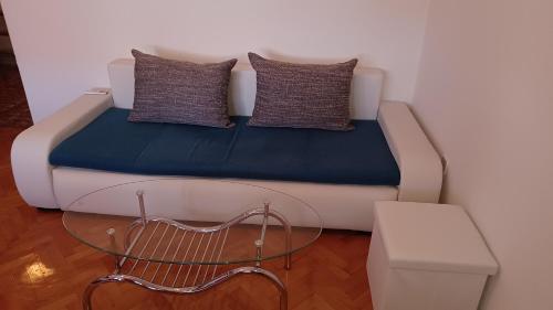 a couch with two pillows and a table in a room at Apartments Pavelić in Crikvenica