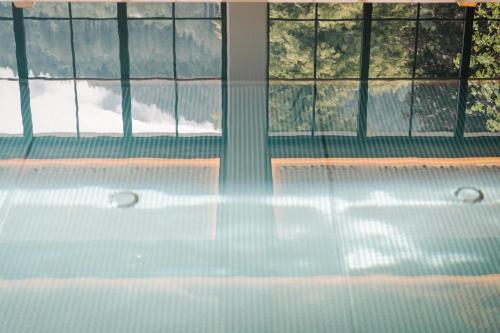 a bath tub in a room with windows at Hotel Bräu in Zell am Ziller