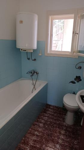 a bathroom with a tub and a toilet and a sink at Apartments Pavelić in Crikvenica