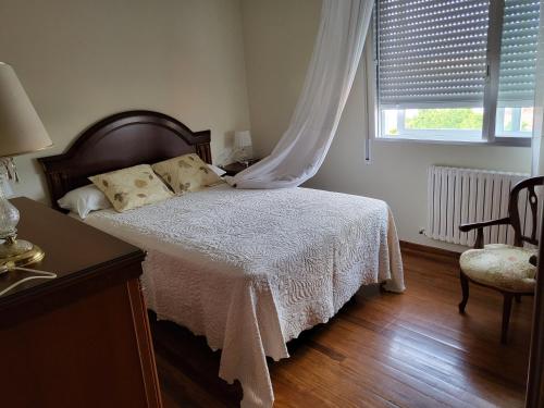 - une chambre avec un lit doté d'une couverture blanche et d'une fenêtre dans l'établissement Apartamento 2 en combarro.. Próximo a Sanxenxo, à Combarro