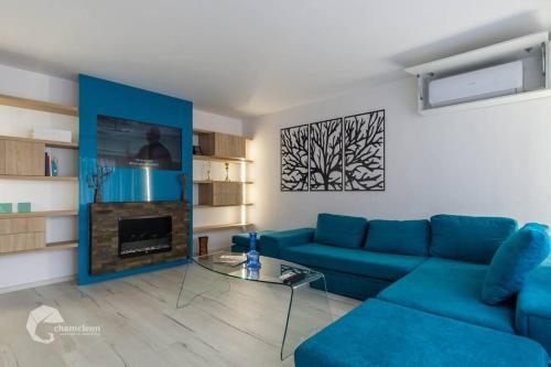 sala de estar con sofá azul y chimenea en Apartament luxos în Onești, en Onești
