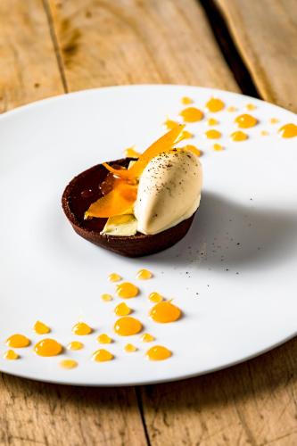 a white plate with a dessert on a table at Hôtel Restaurant Gastronomique La Huchette in Mâcon