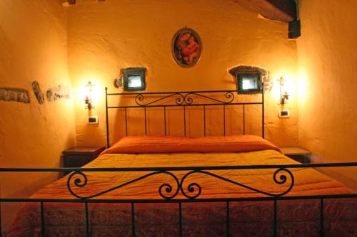 a bed in a bedroom with two lights on the wall at Podere Pian De' Cortini in Serravalle