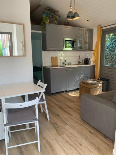 a kitchen and living room with a table and a couch at Tinyhouse Scheveningen beach FREE gated parking in Scheveningen