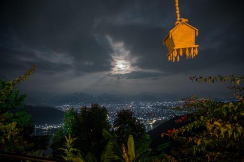 a view of a city at night with a bird house at Raniban Retreat in Pokhara