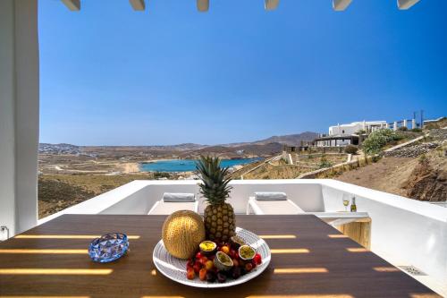 a plate of fruit on a table on a balcony at Nefeli Residence & Suite Ftelia beach Mykonos in Elia