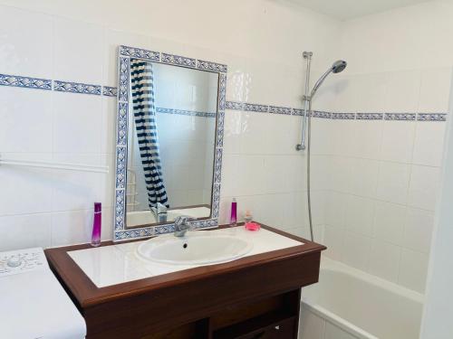 une salle de bain avec un lavabo, un miroir et une baignoire dans l'établissement Maison du lac, golf et océan à 100m, à Saint-Jean-de-Monts