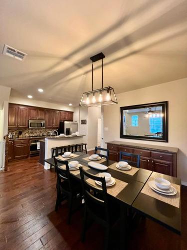 a kitchen and dining room with a table and chairs at Luxury Legacy West Townhouse in Plano