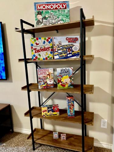 a shelf filled with toys and games at Luxury Legacy West Townhouse in Plano