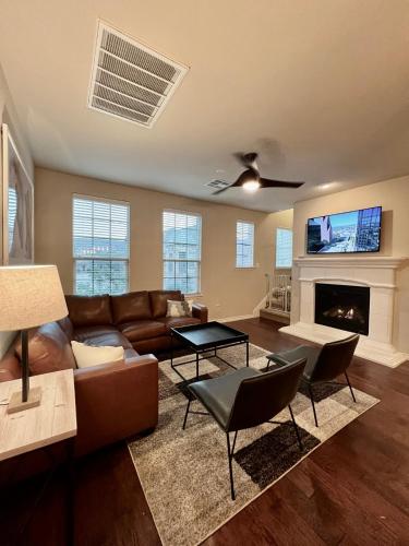 a living room with a couch and a fireplace at Luxury Legacy West Townhouse in Plano