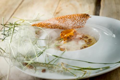 a white plate with food on a table at Hôtel Restaurant Gastronomique La Huchette in Mâcon