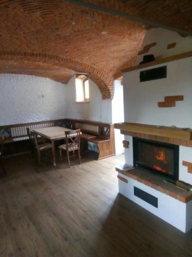 a living room with a fireplace and a table at B&B family room Tubej in Bohinj