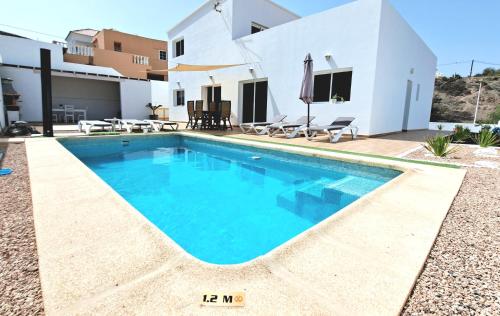 una piscina di fronte a una villa di Villa Calma Climatized pool Private Jacuzzi Spa in Tarajalejo a Tuineje