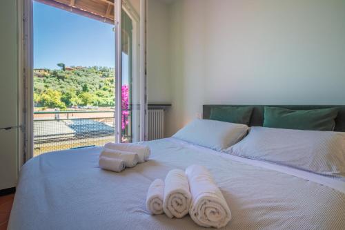białe łóżko z ręcznikami i oknem w obiekcie LA BOUGAINVILLE Relax, Giardino e Parcheggio w mieście Santa Margherita Ligure