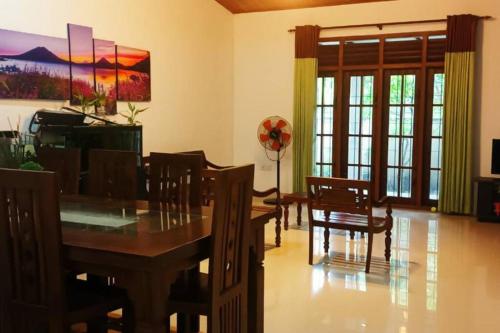 a dining room with a wooden table and chairs at Peaceful Holiday Home in Athurugiriya