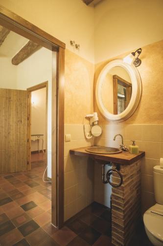 a bathroom with a sink and a toilet and a mirror at Mas Vilar, relax, nature and slow Exclusive Only 6 rooms in Arbúcies