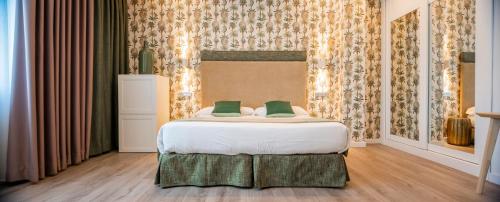 a bedroom with a bed with two green pillows at Hotel Santa Cruz in Cangas de Onís