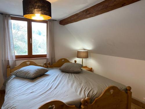 una camera da letto con un letto con due cuscini sopra di Ferme du Val de Bruinen a Sainte-Marie-aux-Mines