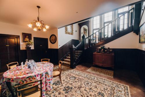 a dining room with a table and a staircase at Villa JKC in Brno