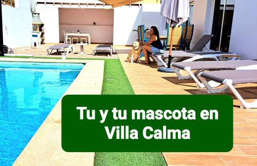 a woman and a dog sitting next to a swimming pool at Villa Calma Climatized pool Private Jacuzzi Spa in Tarajalejo in Tuineje