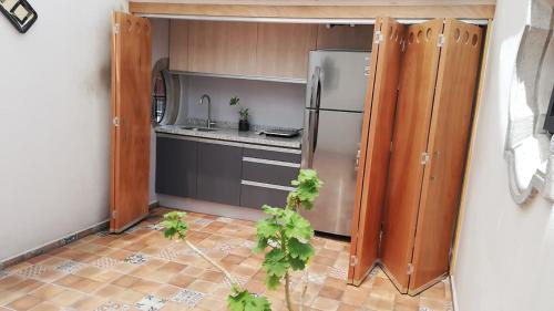 a kitchen with a stainless steel refrigerator and wooden cabinets at Hermosa Suite Privada en Casa Holística in Cuernavaca