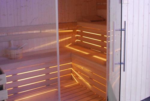 Habitación con suelo de madera y luces en la sauna. en Hotel Elbele Garnì, en Folgaria