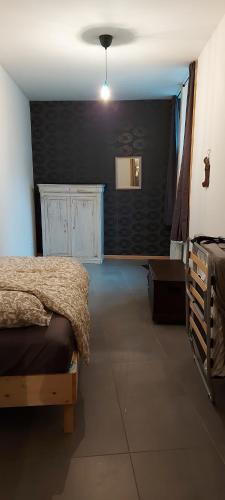 um quarto com uma cama e uma parede preta em APPARTEMENT neuf au centre ville situé au rdc avec terrasse em Givet