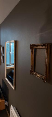 um espelho numa parede ao lado de uma janela em APPARTEMENT neuf au centre ville situé au rdc avec terrasse em Givet