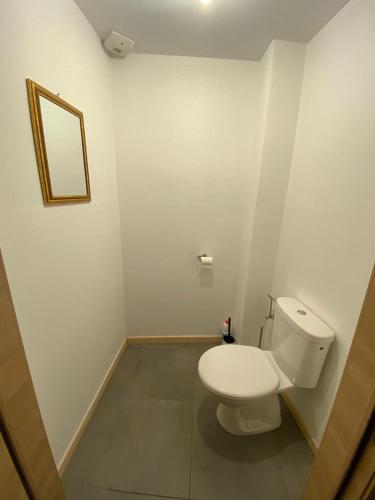 une salle de bain avec des toilettes blanches et un miroir dans l'établissement APPARTEMENT neuf au centre ville situé au rdc avec terrasse, à Givet