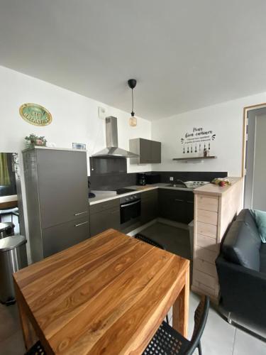 - une cuisine avec une table en bois dans une chambre dans l'établissement APPARTEMENT neuf au centre ville situé au rdc avec terrasse, à Givet