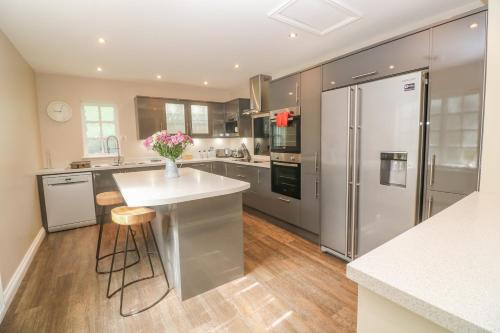 a kitchen with stainless steel appliances and wooden floors at Bodmin Country House in Bodmin