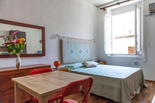 1 dormitorio con mesa, cama, mesa y sillas en S Efisio in Cagliari Centre Q4825, en Cagliari