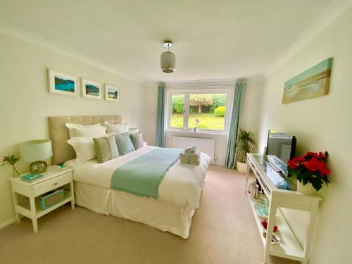 Un dormitorio con una cama grande y una ventana en Ranmore Rise Retreat in the Surrey Hills en Dorking