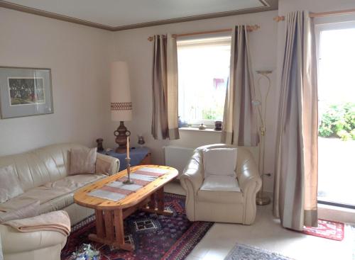 ein Wohnzimmer mit einem Sofa und einem Tisch in der Unterkunft Haus am Deich in Wittdün
