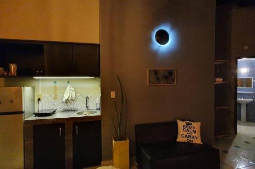 a room with a kitchen with a light on the wall at Ivy House Apart Hotel in Ciudad del Este