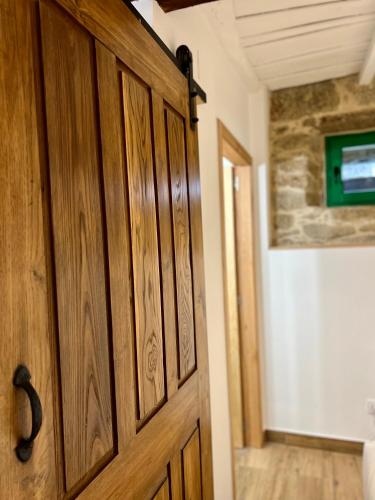 a wooden door in a room with a hallway at A Parada House by Kev in Parada del Sil