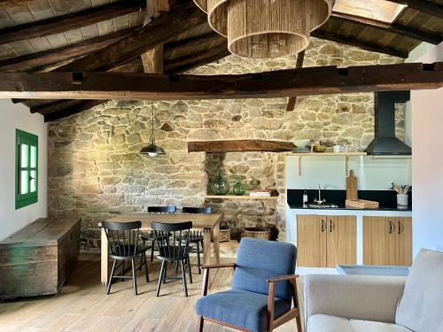 a kitchen and dining room with a table and chairs at A Parada House by Kev in Parada del Sil