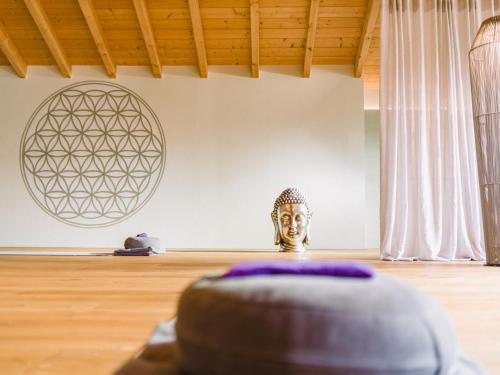 a buddha statue in a room with a wooden floor at Das König Ludwig Inspiration SPA in Schwangau