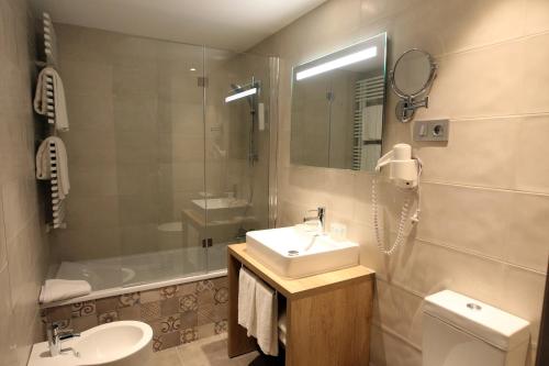 a bathroom with a sink and a toilet and a tub at Hotel & Spa Real Villa Anayet in Canfranc-Estación