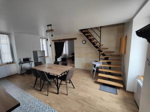 een eetkamer met een tafel en een trap bij L'OASIS - Maison rénovée à 10 min de Beauval in Saint-Romain-sur-Cher