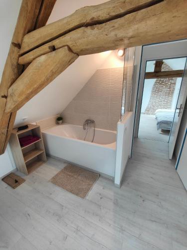 La salle de bains mansardée est pourvue d'une baignoire. dans l'établissement L'OASIS - Maison rénovée à 10 min de Beauval, à Saint-Romain-sur-Cher
